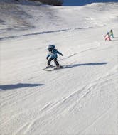 Un giovane sciatore sta sciando con sicurezza su una pista durante una delle Lezioni di sci per bambini (4-14 anni) - Con esperienza organizzate dalla Scuola di Sci Tre Nevi Ovindoli nel comprensorio sciistico di Ovindoli sul Monte Magnola.