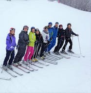 A group of participants is smiling at the camera during the Ski Lessons for Adults - Beginner organized by the ski school Scuola di Sci Tre Nevi Ovindoli in the ski resort of Ovindoli on the Monte Magnola.