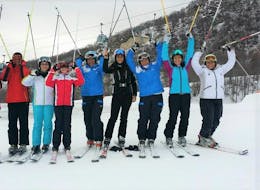 A group of skiers is posing at the camera during the Ski Lessons for Adults - With Experience organized by the ski school Scuola di Sci Tre Nevi Ovindoli in the ski resort of Ovindoli on the Monte Magnola.