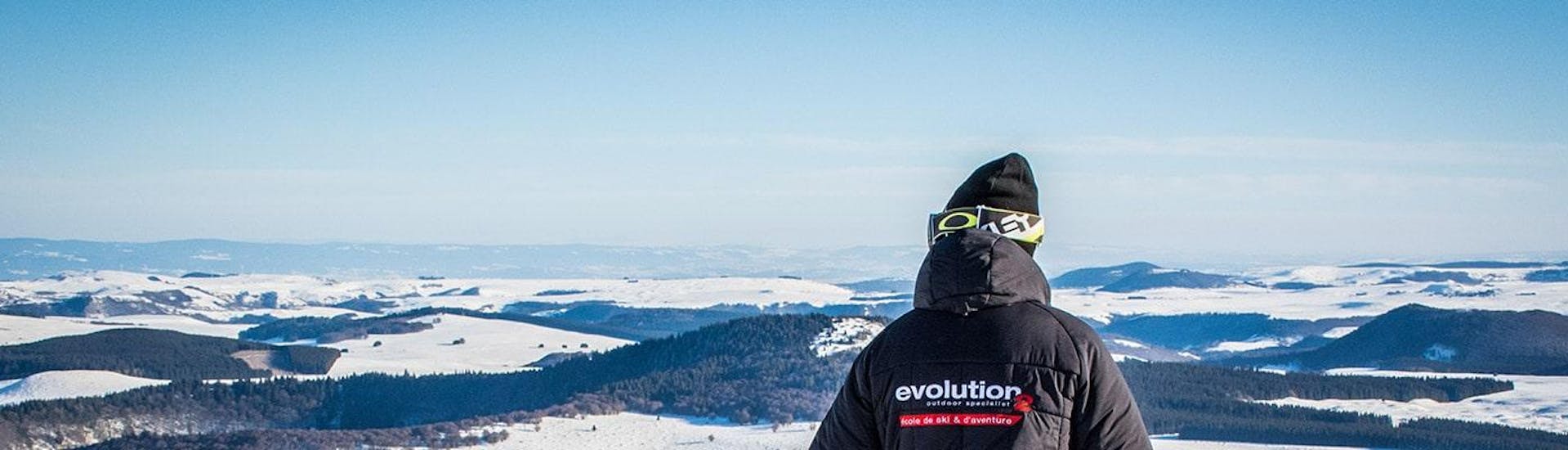 A skier is contemplating the snowy landscape at his foot during his Private Ski Lessons for Kids - All Ages with the ski school Evolution 2 Super Besse.