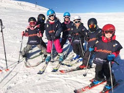 Children are standing at the top of a slope before heading down during their Kids Ski Lessons (6-13 years) - February 9-14 - All Levels with the ski school Evolution 2 Super Besse.
