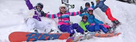 Eine Gruppe Kinder hat sichtlich Spaß bei ihrem Snowboardkurs "Young Boarder Zone" (7-14 Jahre) mit BOARD.AT.