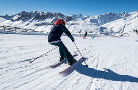 A skier is skiing down a snowy slope with confidence during their Private Ski Lessons for Adults - Praz sur Arly & Flumet with the ski school ESI Snow Diam's.
