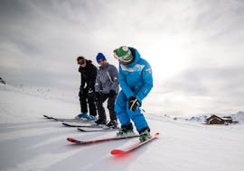 A ski instructor from the ski school ESI Snow Diam's is showing two skiers the right posture on the skis during their Private Ski Lessons for Adults - Crest-Voland.