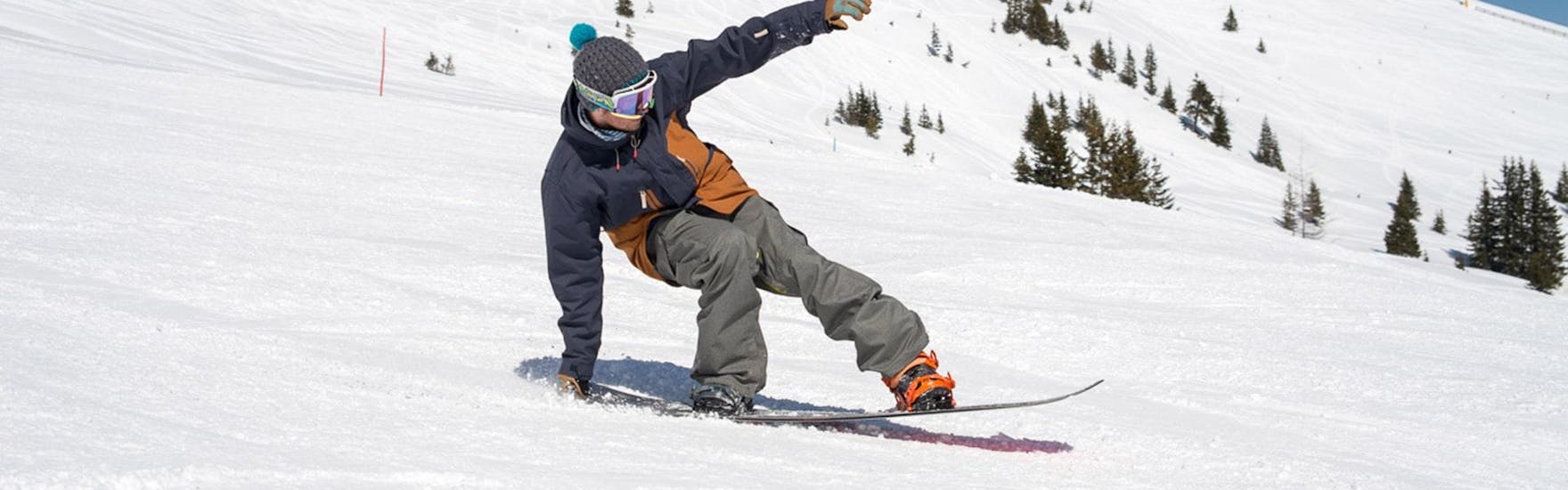 Een snowboarder oefent zijn freestyle moves tijdens een van de Freestyle Snowboard Lessons - Alle niveaus met BOARD.AT.