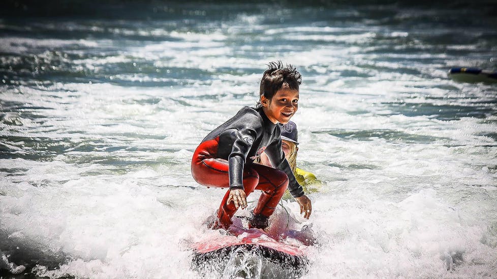 A boy is having fun while surfing during the Surfing Lessons in Jeffreys Bay for Kids & Adults - Beginner organised by Wavecrest Surf School.