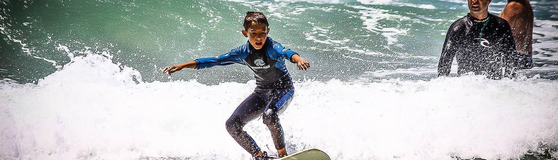 A young boy is having a great time during the Private Surfing Lesson in Jeffreys Bay for Kids & Adults with his surfing instructor from Wavecrest Surf School.