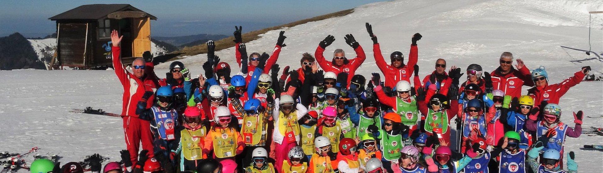 Students from the the swiss ski school Charmey and their ski instructors are gathered for a group photo celebrating their Kids Ski Lessons (6-15 years) - 1 day.