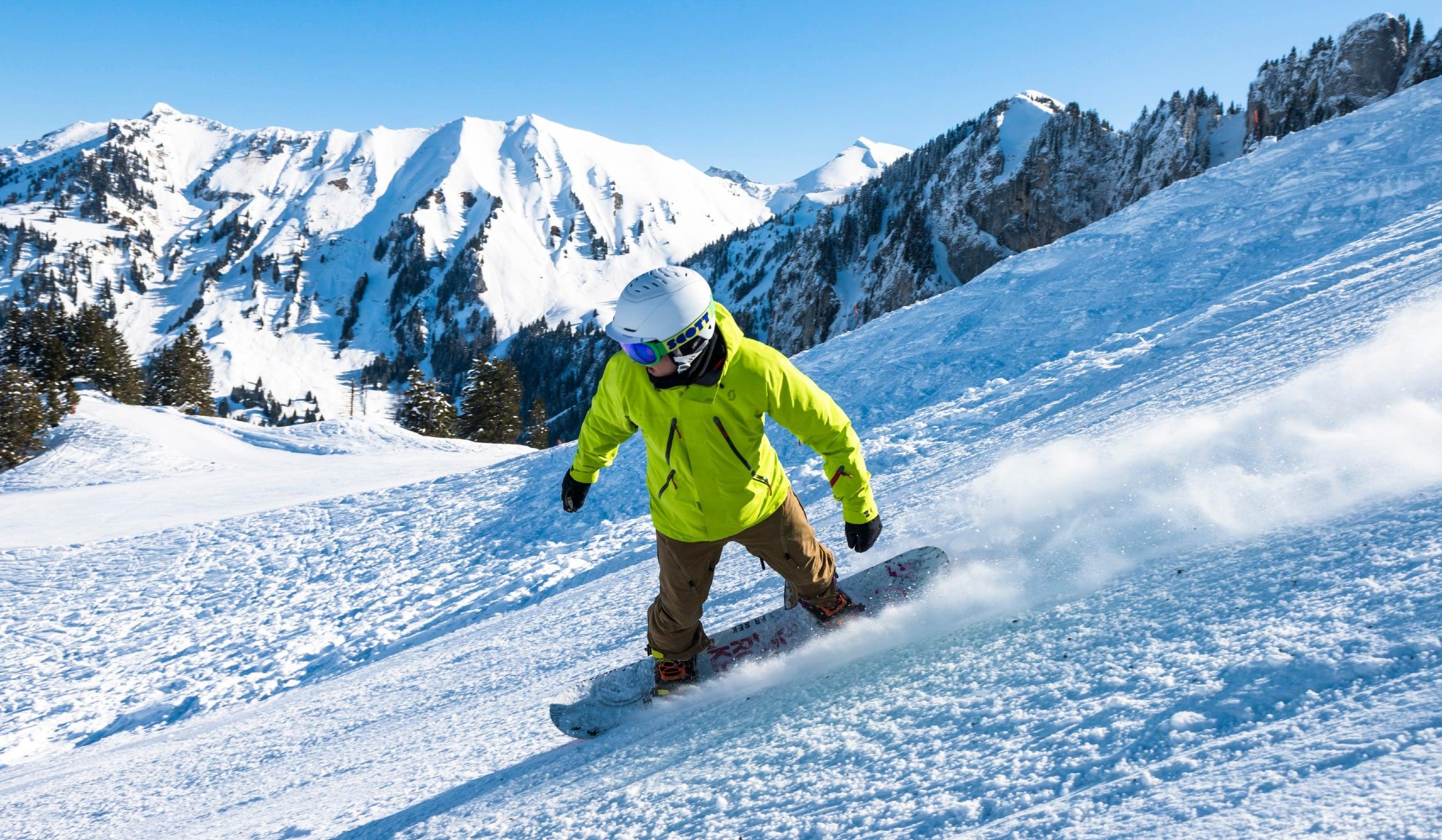 A snowboarder is going down a slope with confidence thanks to his Snowboarding Lessons (6-15 years) - 1 day with the swiss ski school Charmey.