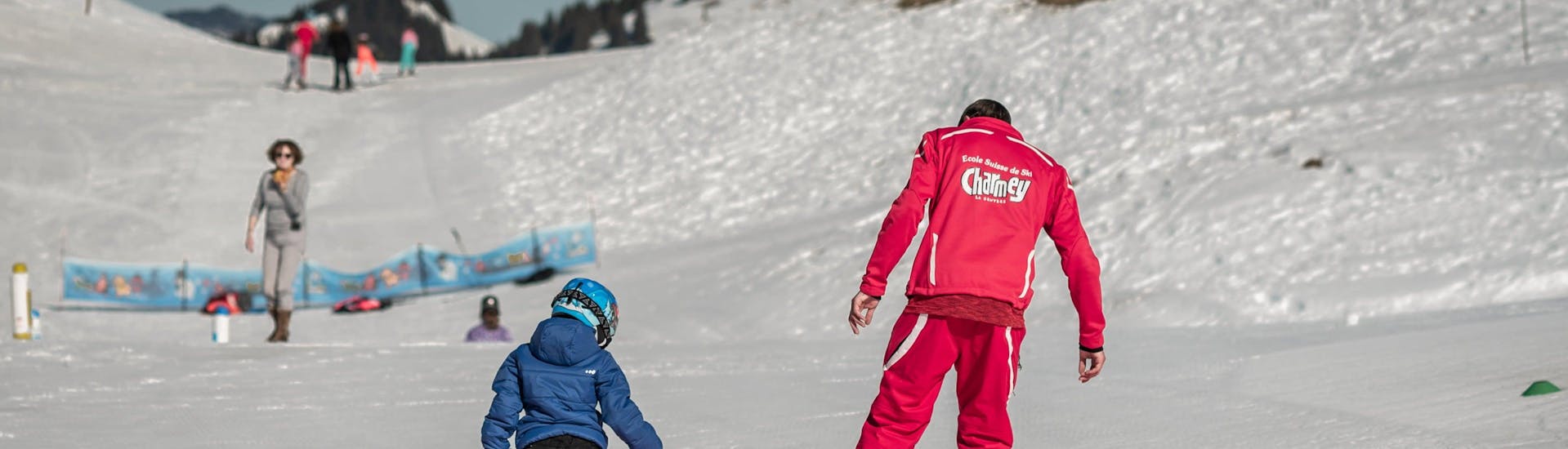 Un enfant apprend les bases du ski avec son moniteur de ski de l'école de ski suisse Charmey pendant son Cours particulier de ski Enfants (dès 3 ans) - Tous niveaux.