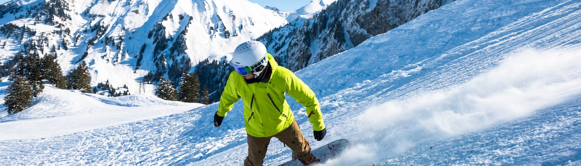 Un snowboardeur descend une piste avec assurance grâce à son Cours particulier de snowboard - Tous niveaux & âges avec l'école de ski suisse Charmey.