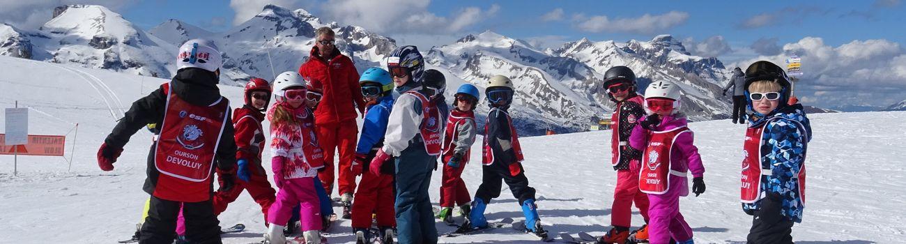Kids are standing at the top of the slope ready to start their Kids Ski Lessons (6-12 y.) - February - Afternoon - Beginner with the ski school ESF du Dévoluy.