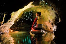 A girl is admiring the glow worms in a cave during the Paddle Board Rotorua - Glow Worm Tour Winter organized by Paddle Board Rotorua in the lake district of Rotorua.