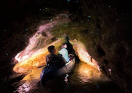 Two participants of the Kayak Rotorua - Twilight Glow Worm Tour are admiring the glow worms in a cave of the Lake Okareka during the activity organized by Paddle Board Rotorua.