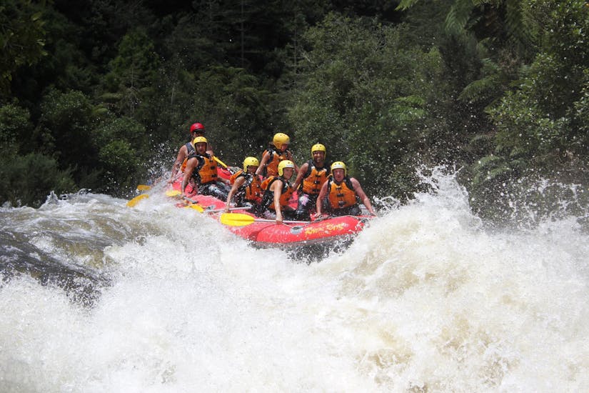 A group of rafters fights their way through the rapids and enjoys the view during the rotorua rafting pure new zealand - rangitaiki river tour with River Rats Rotorua Raft & Kayak.