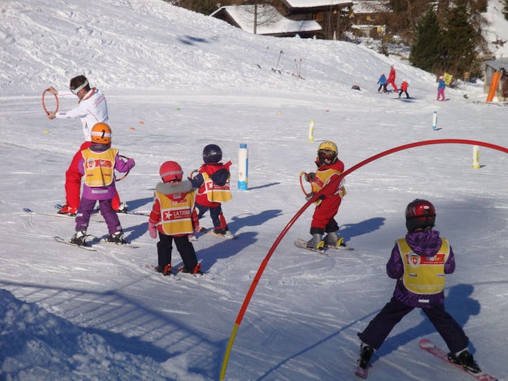 Kinderen leren de basis van het skiën dankzij spelletjes in de veiligheid van de sneeuwtuin tijdens hun kinderskilessen "Snowgarden" (3-6 jaar) - Ochtend met de Zwitserse skischool La Tzoumaz.
