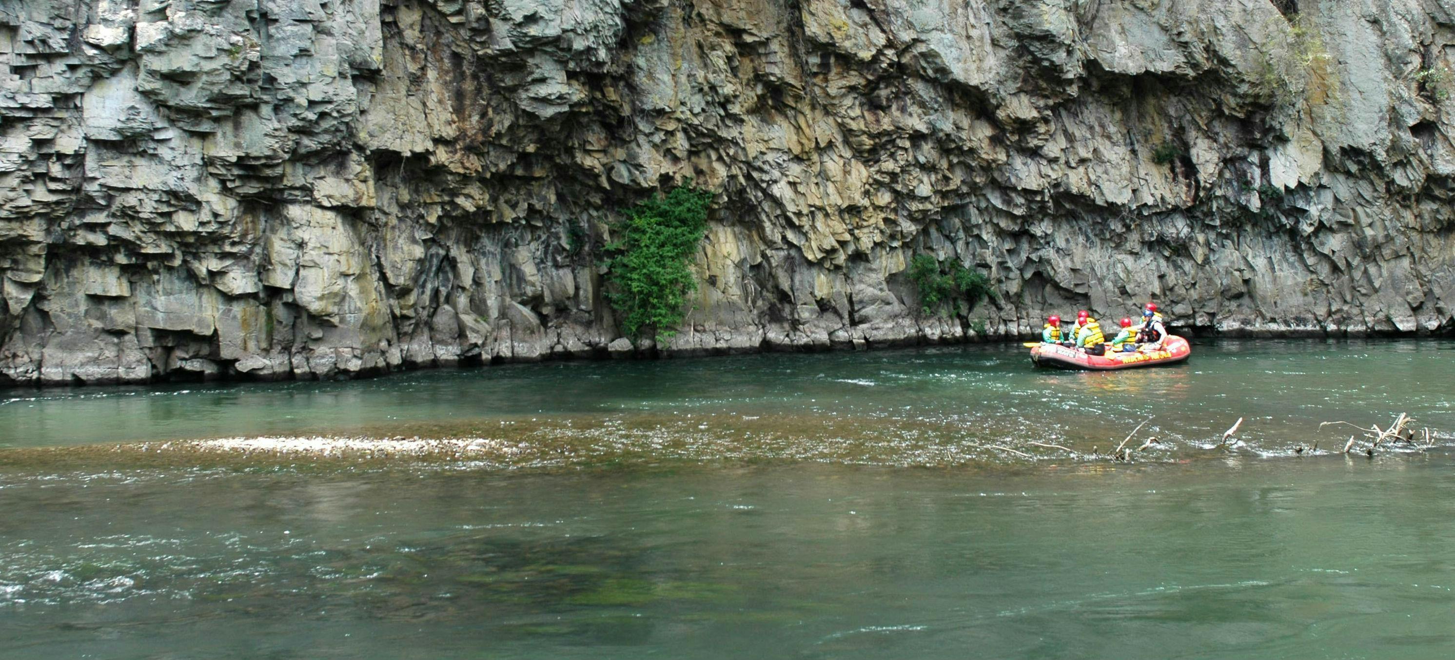 The tour participants pass a beautiful stone wall and fight their way through the rapids during the rotorua rafting scenic trip - rangitaiki river with River Rats Rotorua Raft & Kayak. 