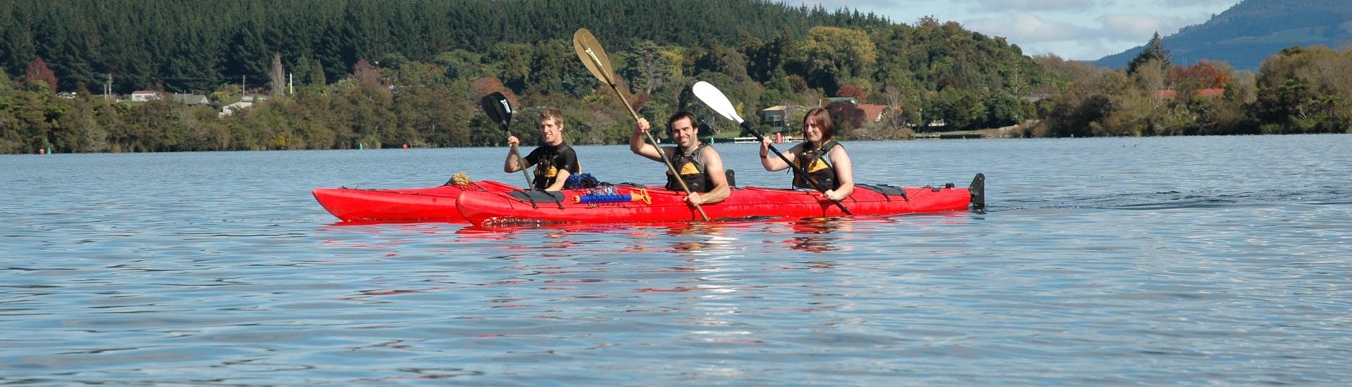 The tour participants paddle in a relaxed way on the calm lake during the kayak rotorua guided hot pools summer - lake rotoiti with River Rats Rotorua Raft & Kayak. 