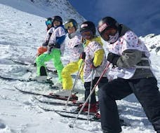 Kids are standing in the middle of the slope during their Kids Ski Lessons (4-12 years) - High Season -With Experience with the Swiss Ski School La Tzoumaz.