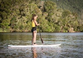 A girl is learning how to paddle during the Paddle Board Rotorua - Glow Worm Tour Summer organized by Paddle Board Rotorua.