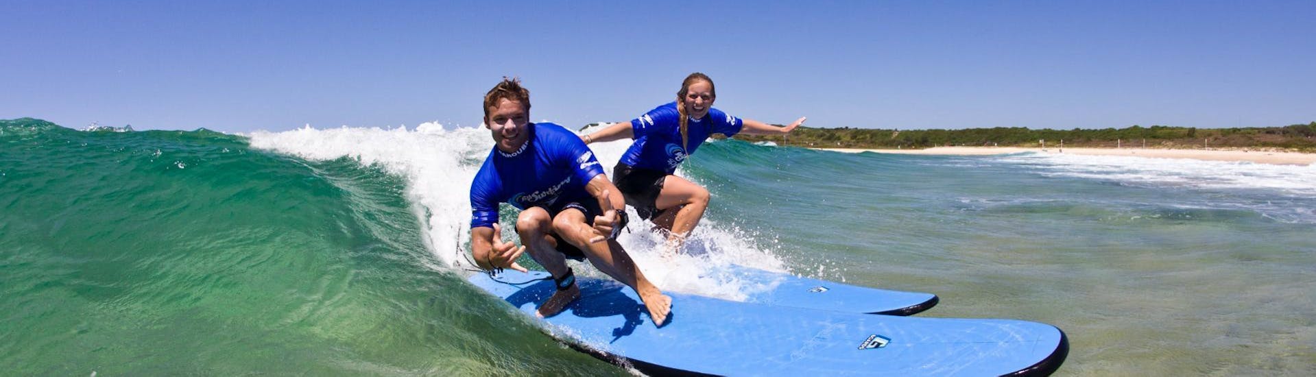 Two friends are having a great time on a surfboard during the Surfing Lessons in Maroubra for Teens & Adults - Beginner organised by Let's Go Surfing.