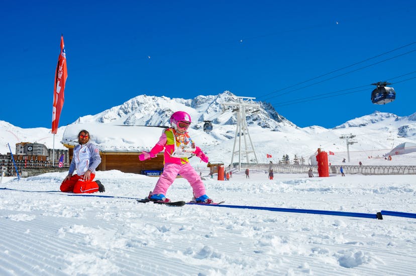 A little girl experiences her first gliding thrills during a "piou-piou" kids ski lesson with ESF Val Thorens. 