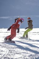 Des apprentis snowboardeurs descendent une piste en compagnie de leur moniteur de l'ESF Val Thorens durant un cours de snowboard (dès 7 ans) avec ESF Val Thorens.