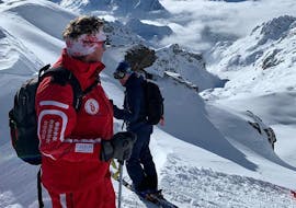 Un maestro di sci della Scuola Svizzera di Sci La Tzoumaz e uno sciatore si affacciano sulle montagne intorno a La Tzoumaz durante le lezioni private di sci freeride - tutti i livelli.
