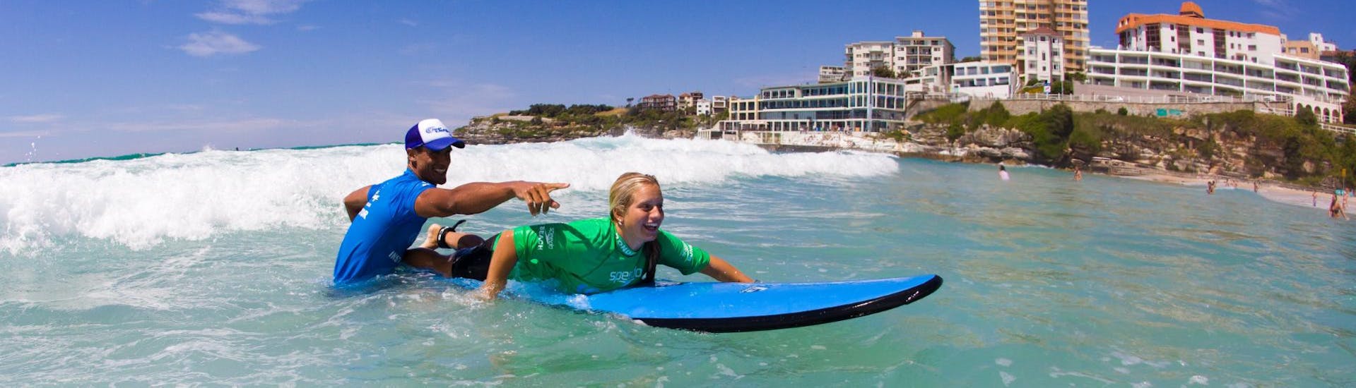 During the Surfing Lessons in Bondi Beach for Teens & Adults - Beginner, a young woman is having great time whilst learning how to surf under the guidance of an experienced surf instructor from Let’s Go Surfing.