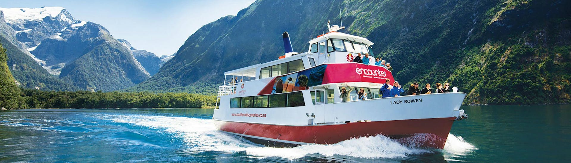 One of the Southern Discoveries ships is cruising along New Zealand's most famous fjord during the Encounter Nature Cruise in Milford Sound - Winter.