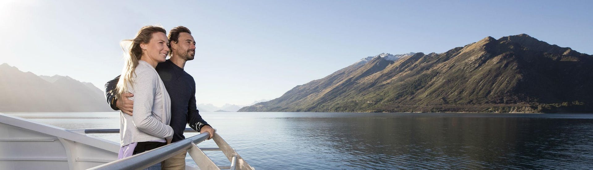 A couple is enjoying the view from the catamaran's viewing deck during the Spirit of Queenstown Cruise on Lake Wakatipu organised by Southern Discoveries.