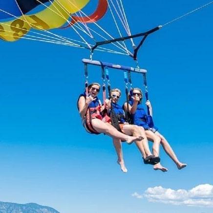 Three people flying on a parasail during Private Parasailing from Sorrento, Naples or Capri with Capitano Ago.