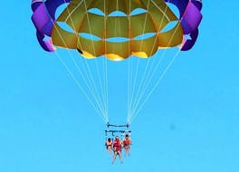 A father and his kids gliding above the beautiful coastline of Albufeira on their Parasailing Tour in Albufeira "Family Package" with the experienced team from Dream Wave.
