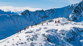 Un groupe de skieurs se tient dans la neige profonde et se prépare au parcours avec son moniteur pendant les cours de ski freeride - Tous les niveaux de l'école de ski S4 Freeride Experts.