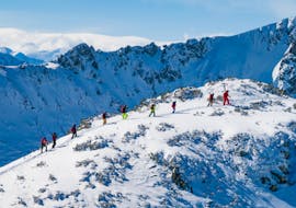 Un grupo de esquiadores permanecen en nieve profunda y se preparan para el curso con su insturctor durante las clases de freeride - Todos los niveles de la escuela de esquí S4 Freeride Experts.