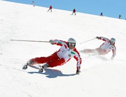 Due maestri privati di sci stanno scendendo in sicurezza le piste del comprensorio sciistico della Via Lattea durante una delle lezioni private di sci per adulti - tutti i livelli organizzate dalla Scuola di Sci Sauze Sportinia.