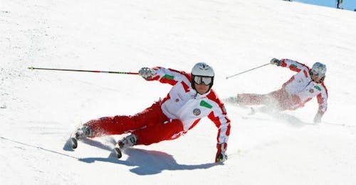 Privélessen skiën voor volwassenen van alle niveaus met Scuola di Sci Sauze Sportinia Twee skileraren dalen af van de piste in het skigebied Via Lattea tijdens de cursus Privélessen skiën voor volwassenen - Alle niveaus van Scuola di Sci Sauze Sportinia.