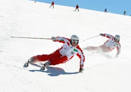 Deux moniteurs de ski particuliers domptent les pistes de la station de ski de Via Lattea pendant les cours de ski particuliers pour adultes - tous niveaux organisés par l'école de ski Scuola di Sci Sauze Sportinia.