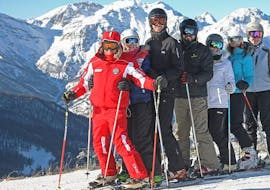 Dei partecipanti delle lezioni di sci per adulti - tutti i livelli organizzate dalla Scuola di Sci Sauze Sportinia si stanno divertendo con il maestro di sci sulle psite del comprensorio sciistico della Via Lattea.