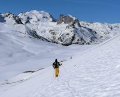 Il maestro privato delle lezioni private di sci freeride - avanzate della Scuola di Sci Sauze Sportinia sta aprendo la pista sulla neve fresca su un pendio innevato del comprensorio sciistico della Via Lattea.