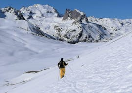 Le moniteur des cours de ski freeride particuliers - expérimentés organisés par l'école de ski Scuola di Sci Sauze Sportinia descend une montagne enneigée dans la station de ski de Via Lattea.