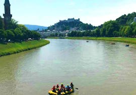 A group of people enjoying the magnificent view on the City of Salzburg during their Rafting tour on Salzach river with Torrent Outdoor Experience.
