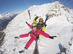 Ein Tandempilot und sein Passagier fliegen während ihrem Flug Tandem Paragleiten "Entdecker" von Flybypara über die verschneiten Berge von Zermatt.