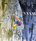 Eine Frau, die bei Ihrer Klettersteig Tour für Abenteurer mit den erfahrenen Bergführern von Bergführer Salzburg die steile "Gamsleckenwand" hinauf klettert.