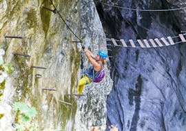 Eine Frau, die bei Ihrer Klettersteig Tour für Abenteurer mit den erfahrenen Bergführern von Bergführer Salzburg die steile "Gamsleckenwand" hinauf klettert.