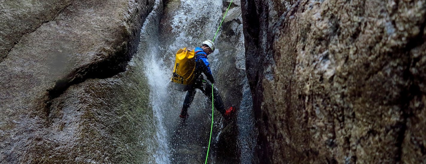 A guy abseils at sunset during the Night Canyoning in the Sorba with Monterosa Canyoning.