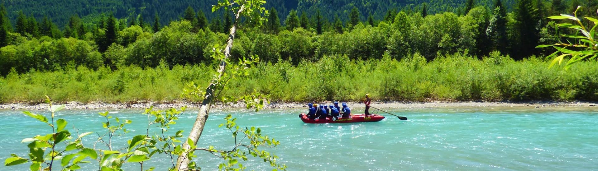 During their Half Day Rafting Tour on the Lech River with Fun Rafting Lechtal, the participants paddle through the green landscape of the Lechtal valley.