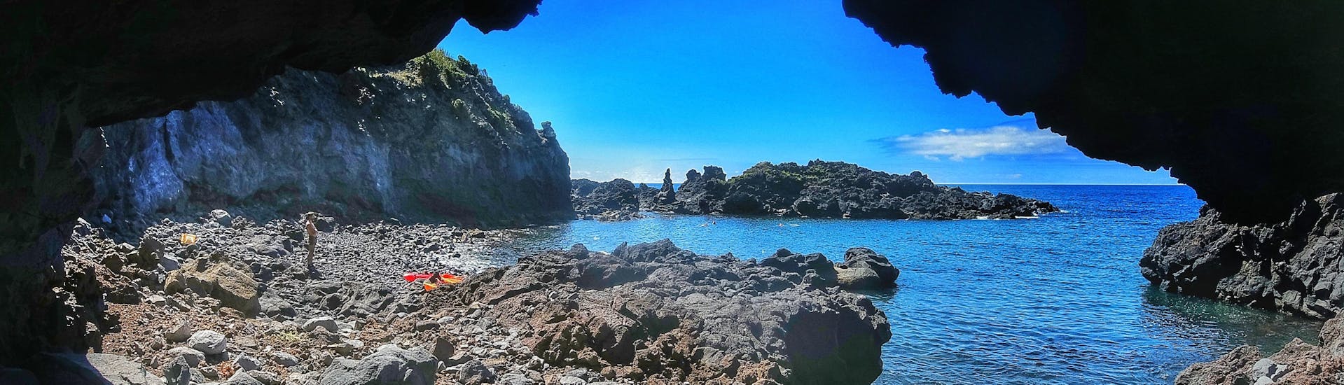 Vue sur une plage rocheuse depuis une grotte pendant une sortie en Kayak de mer le long de la côte à Caloura avec Fun Activities Azores Adventures.