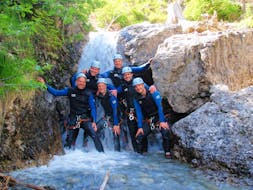 Beim Fun-Canyoning in der Wiesbachschlucht mit Fun Rafting Lechtal posiert eine Gruppe von Freunden vor einem Wasserfall für ein Foto.