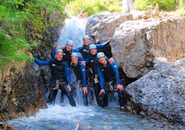 Beim Fun-Canyoning in der Wiesbachschlucht mit Fun Rafting Lechtal posiert eine Gruppe von Freunden vor einem Wasserfall für ein Foto.